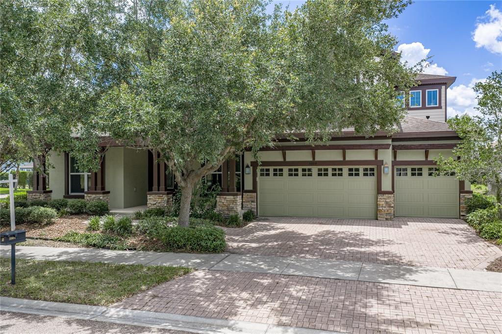 A two-story house with a three-car garage, stone accents, and a brick paver driveway — 5904 SHELL RIDGE DRIVE, LITHIA, FL