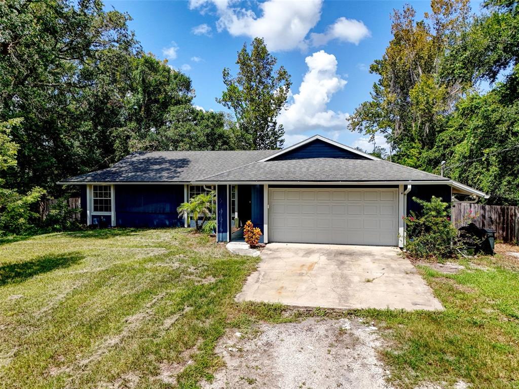 A single-story house with blue siding, a two-car garage, and a concrete driveway — 2380 PEMBERTON STREET, OVIEDO, FL