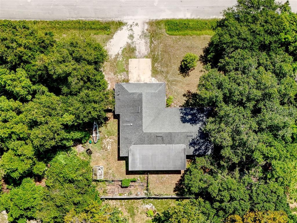 An aerial view shows a house with a dark roof surrounded by dense green trees — 2380 PEMBERTON STREET, OVIEDO, FL
