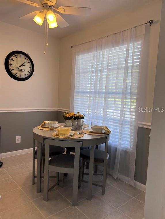 A dining area features a round table with four chairs, a ceiling fan, and wall clock — 2530 BLACK OLIVE BOULEVARD, DELRAY BEACH, FL