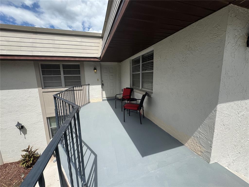 A view from a doorway looking out onto a covered balcony with a metal railing — 170 WINDTREE LANE, WINTER GARDEN, FL