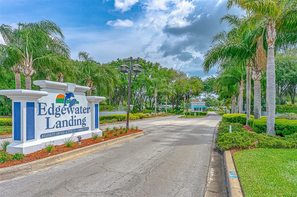 The entrance sign for Edgewater Landing, a 55+ community, stands beside a paved road — 509 STARBOARD AVENUE, EDGEWATER, FL