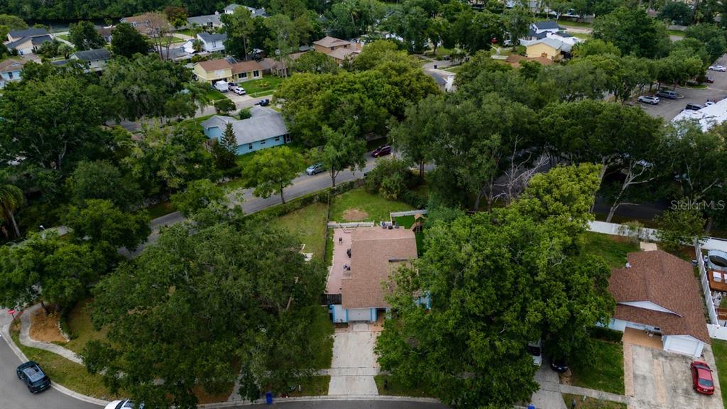 An aerial view shows a residential house with a brown roof and backyard playground — 16317 CALIENTE PLACE, TAMPA, FL
