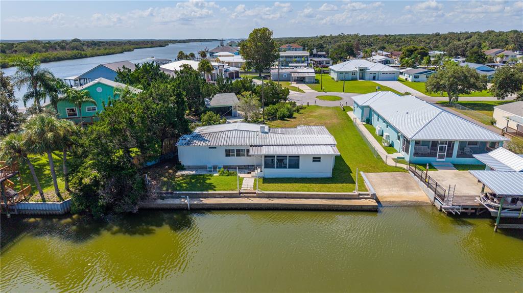 An aerial view of a waterfront house with a metal roof and a concrete seawall — 286 RANDLE AVENUE, OAK HILL, FL