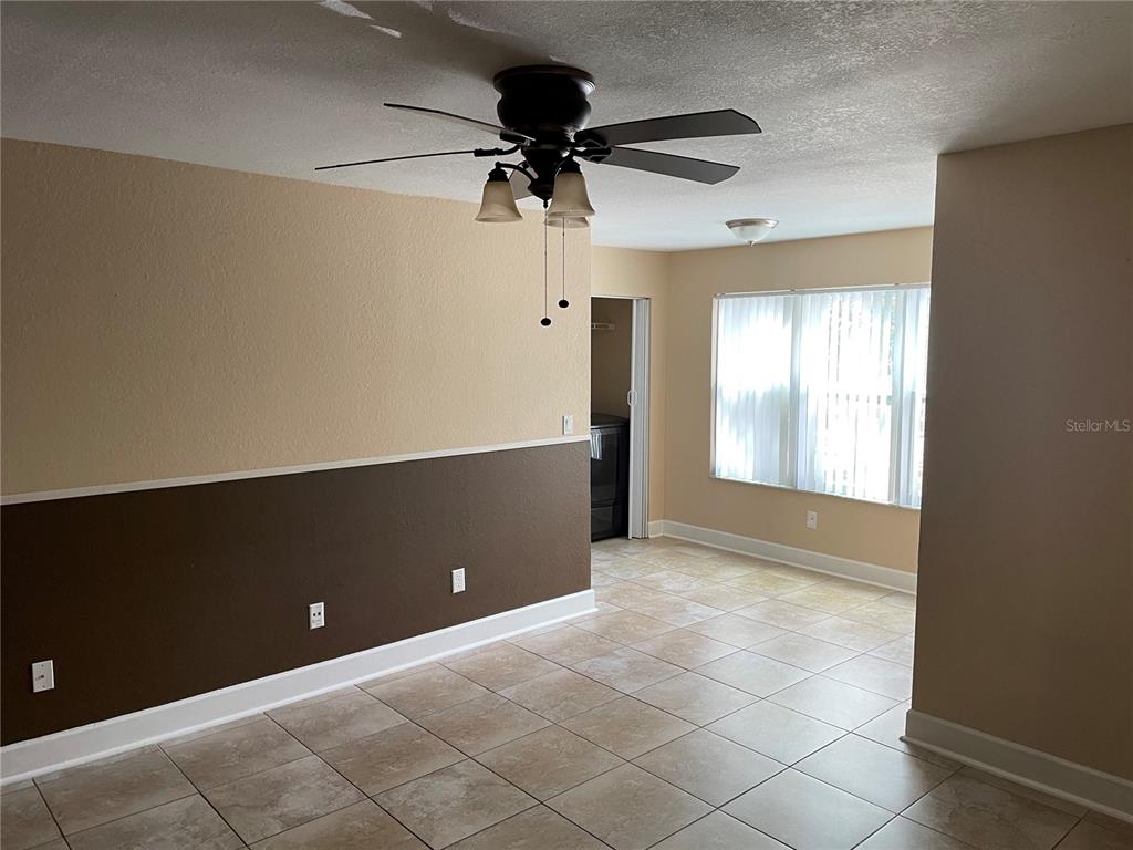 A room with tile flooring, a ceiling fan, and two-toned walls with a chair rail — 4512 COMMANDER DRIVE UNIT 1725, ORLANDO, FL
