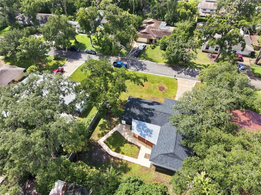 An aerial view shows a house with a dark roof, a patio, and surrounding trees — 6622 GLENCOE DRIVE, TEMPLE TERRACE, FL