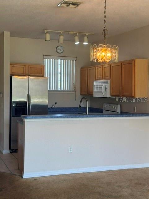 A kitchen features light wood cabinets, a stainless steel refrigerator, and a blue countertop — 418 MONROE CIRCLE, DAVENPORT, FL