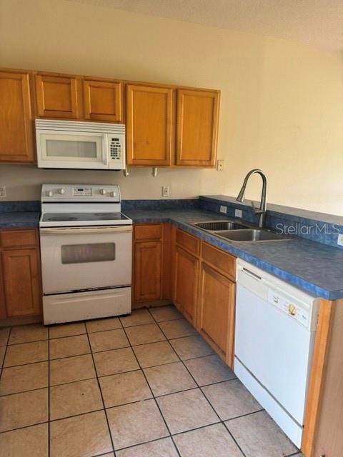 A kitchen features wood cabinets, a white stove, a microwave, and a blue countertop — 418 MONROE CIRCLE, DAVENPORT, FL