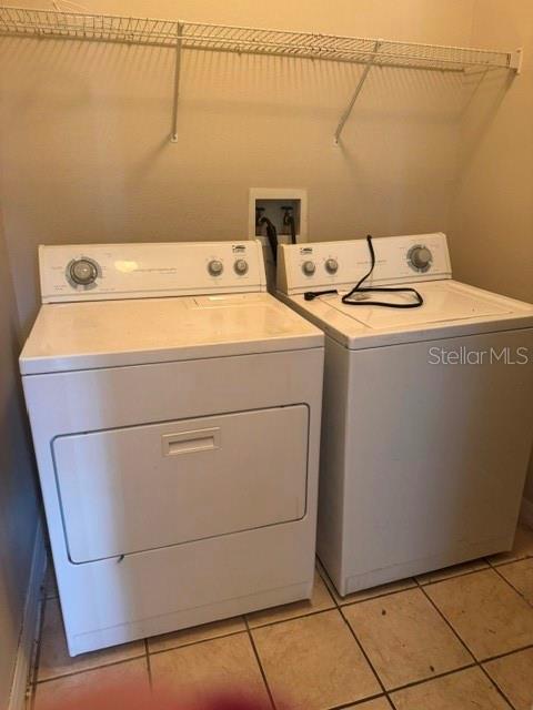 A laundry room features a white washer and dryer beneath a wire shelving unit — 418 MONROE CIRCLE, DAVENPORT, FL