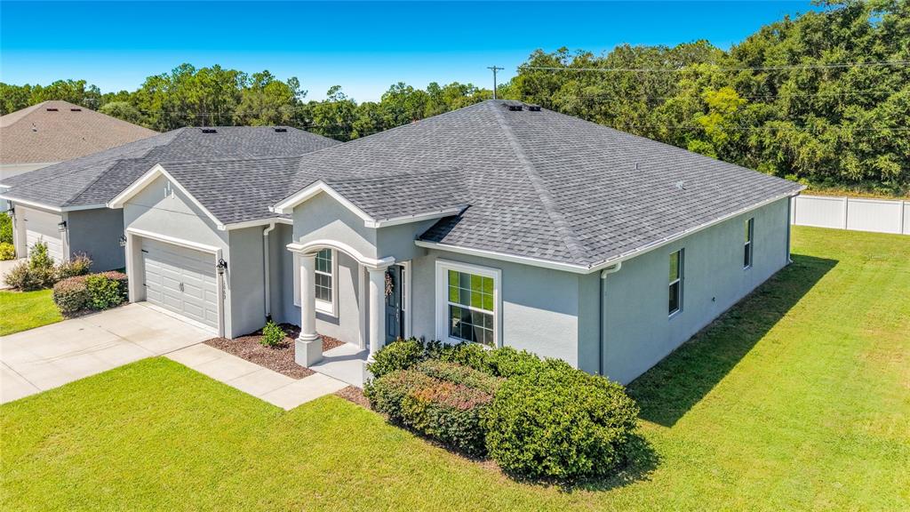 An aerial view of a single-story gray house with a shingled roof and front lawn — 1069 SANDPIPER LOOP, WINTER HAVEN, FL