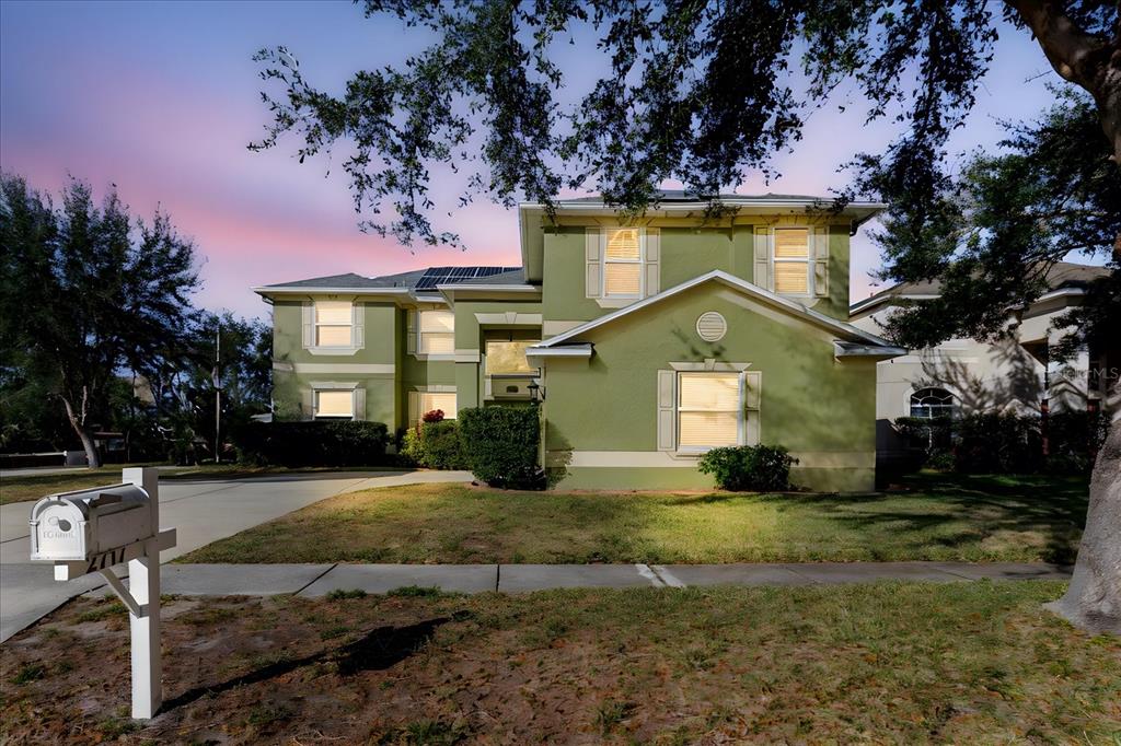 A two-story green house with solar panels on the roof and a front mailbox — 2717 AVON RIVER DRIVE, VALRICO, FL