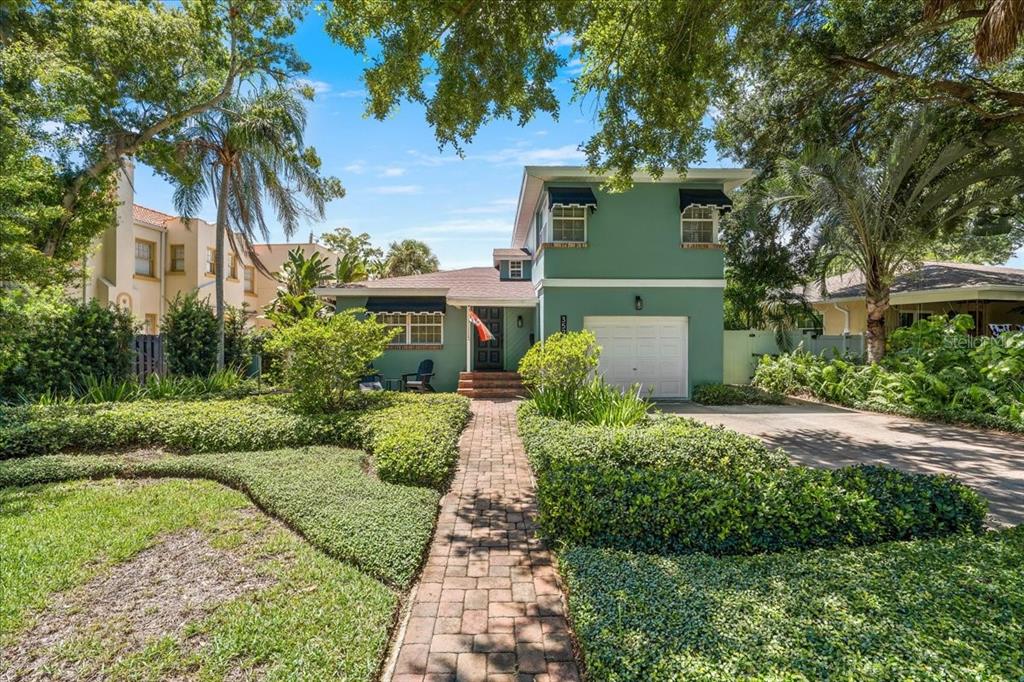 A two-story green house with a brick walkway and a front-facing garage — 3528 FOSTER HILL DRIVE N, ST PETERSBURG, FL