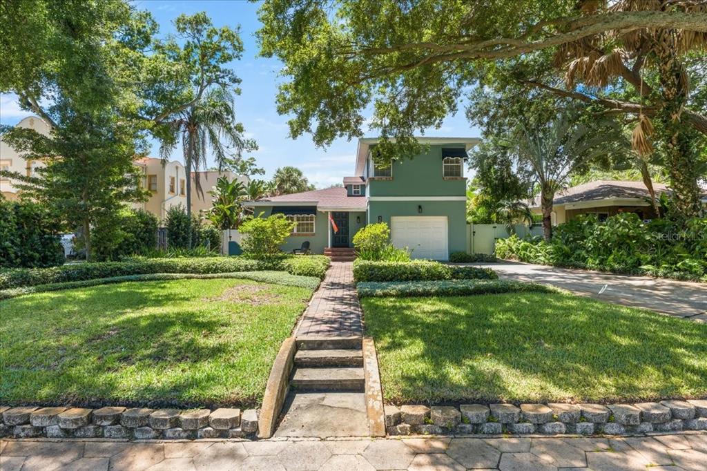 A two-story green house with a brick walkway, front lawn, and attached garage — 3528 FOSTER HILL DRIVE N, ST PETERSBURG, FL