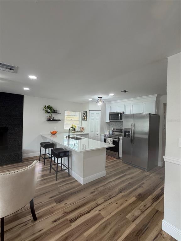 An entryway leads into a dining area with a glass table, chairs, and wood-look flooring — 3001 E FERN STREET, TAMPA, FL