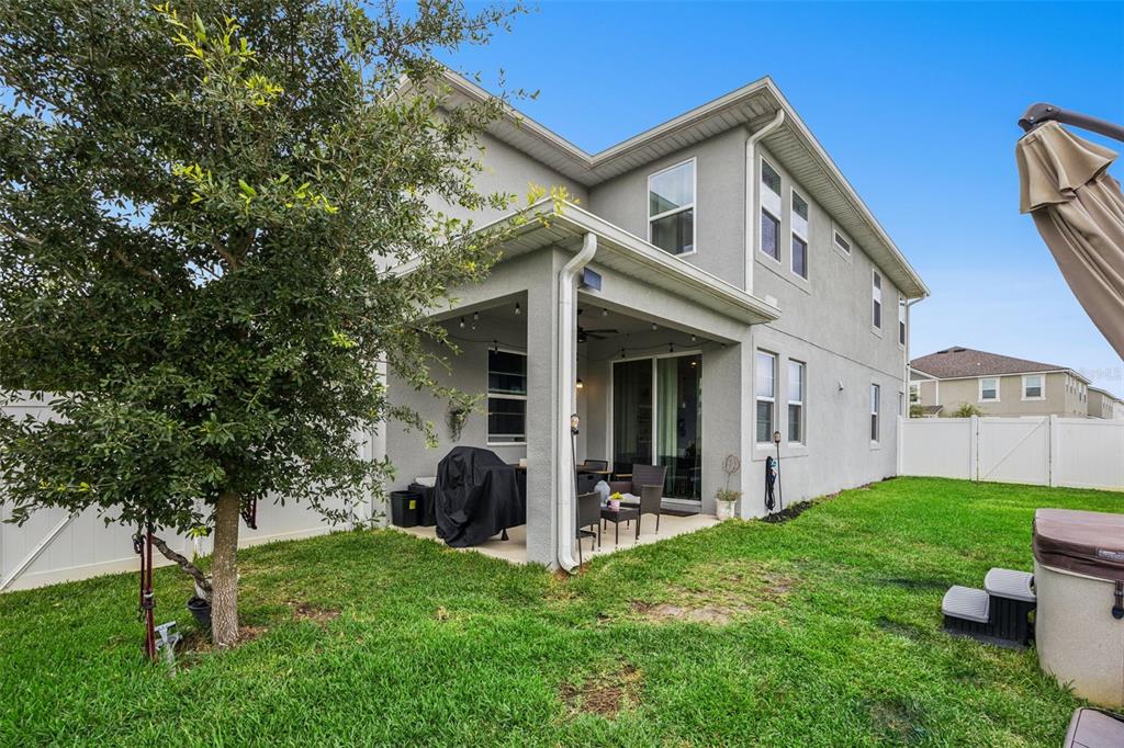 A two-story house with a white exterior, a covered front porch, and a white fence — 11492 SUNSAIL AVENUE, ORLANDO, FL