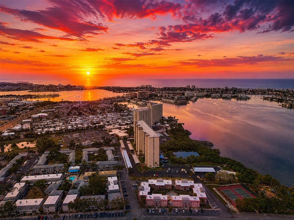 An aerial view of a coastal residential area at sunset with high-rise apartment buildings — 7001 PLACE DE LA PAIX UNIT 2A, SOUTH PASADENA, FL