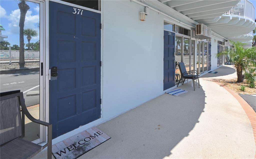 A row of blue doors with unit numbers on a concrete walkway outside a building — 18399 GULF BOULEVARD UNIT 371, INDIAN SHORES, FL