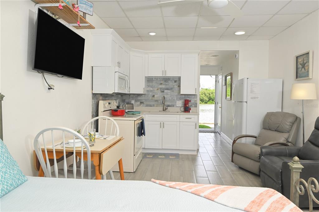 A studio apartment features a small kitchen, dining area, and living space with water views — 18399 GULF BOULEVARD UNIT 371, INDIAN SHORES, FL