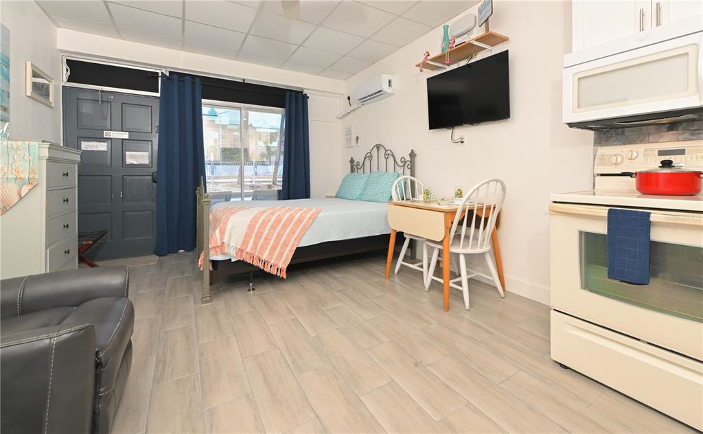 A small kitchen with white cabinets, a tiled backsplash, and a view of the water — 18399 GULF BOULEVARD UNIT 371, INDIAN SHORES, FL