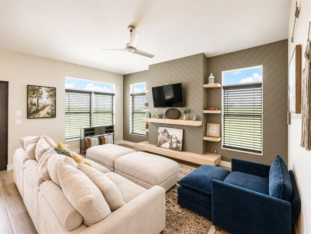 A living room features a brown sectional sofa, a patterned rug, and a kitchen background — 2481 NE FAYE TERRACE, ARCADIA, FL