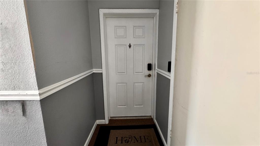 A carpeted staircase with a black metal railing and a small lockbox on a step — 205 LEWFIELD CIRCLE UNIT 205, WINTER PARK, FL