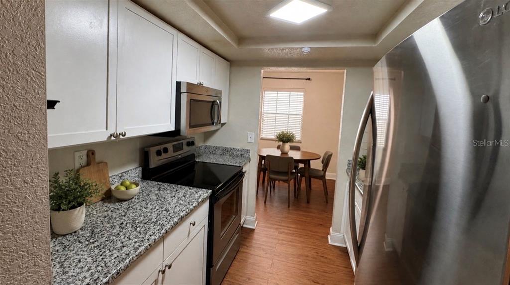 A white apartment door labeled 205 is set in a gray hallway with a doormat — 205 LEWFIELD CIRCLE UNIT 205, WINTER PARK, FL