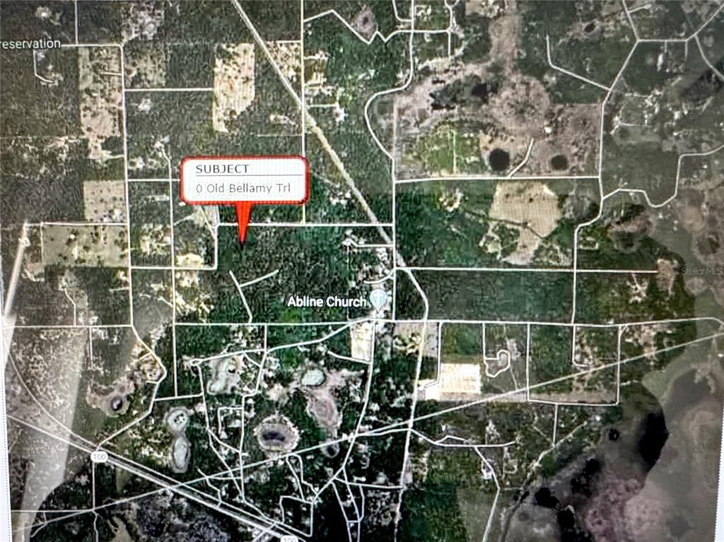 An aerial map shows a wooded land parcel marked with a red location pin — OLD BELLAMY TRAIL, MELROSE, FL