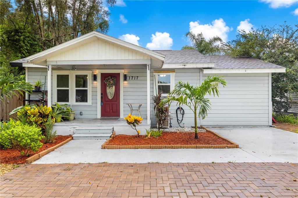 A single-story house with light gray siding, a red front door, and a paved driveway — 1717 W MOHAWK AVENUE, TAMPA, FL