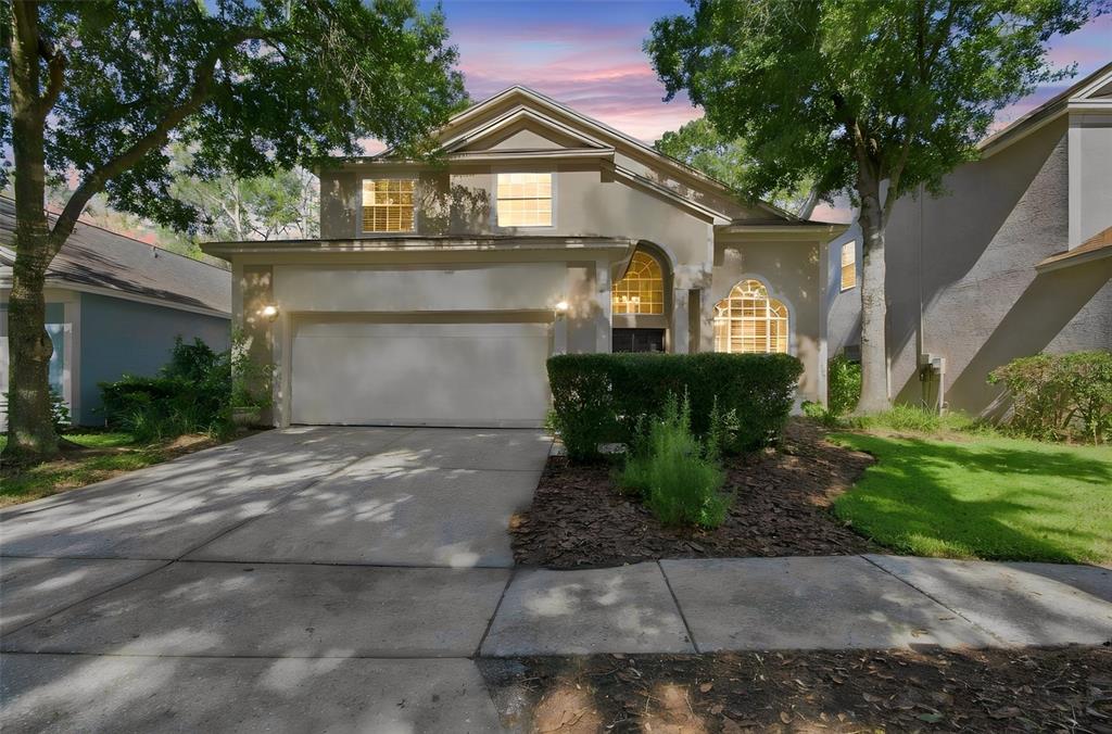 A two-story suburban house features a two-car garage, arched windows, and a landscaped front yard — 17708 LONG RIDGE ROAD, TAMPA, FL