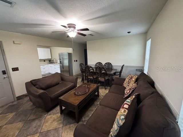 A living room with brown sofas and a dining area with a table and chairs — 14373 IRVING STREET, SPRING HILL, FL