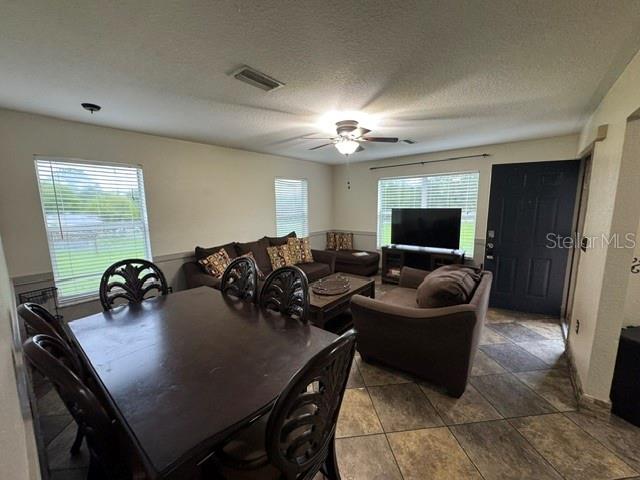 A dining area with a dark wood table and chairs opens into a living room — 14373 IRVING STREET, SPRING HILL, FL