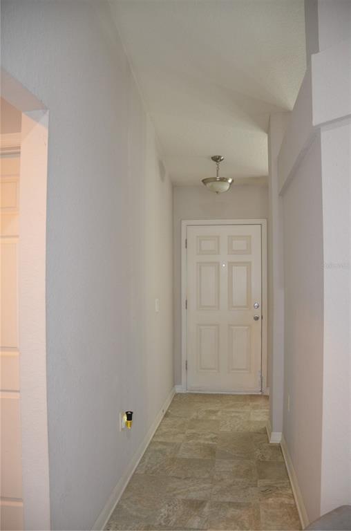 A narrow entryway features light-colored walls, a tiled floor, and a white front door — 9916 SW 56TH AVENUE, OCALA, FL