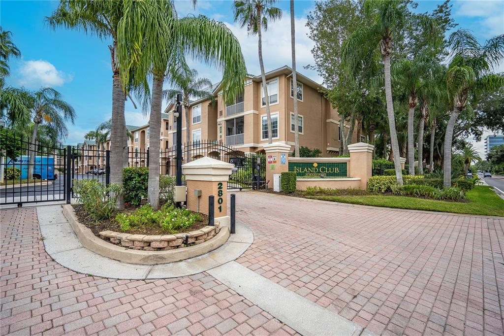 An aerial view shows a swimming pool, a long wooden pier, and a parking lot — 3205 BAY CLUB CIRCLE UNIT 3205, TAMPA, FL