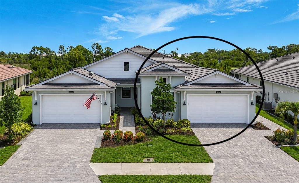 An aerial view shows the fenced backyard and screened patio of a suburban house — 18604 DAYSPRING PLACE, VENICE, FL