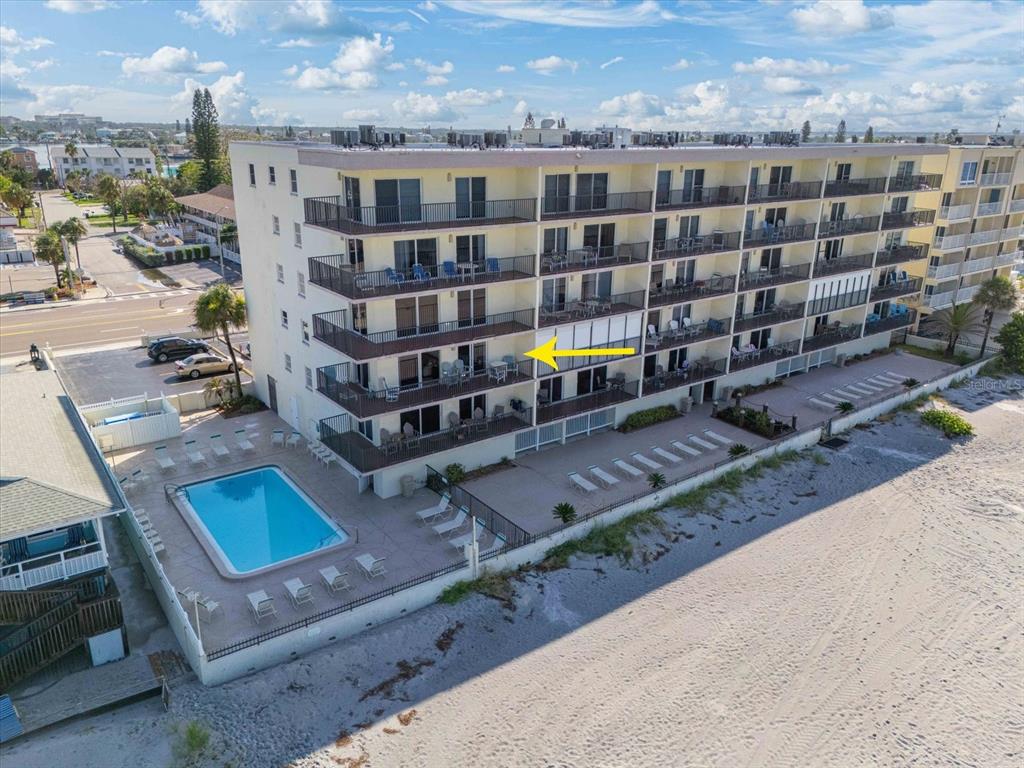 An aerial view of a multi-story beachfront condominium building with a pool and sandy beach — 14300 GULF BOULEVARD UNIT 206, MADEIRA BEACH, FL