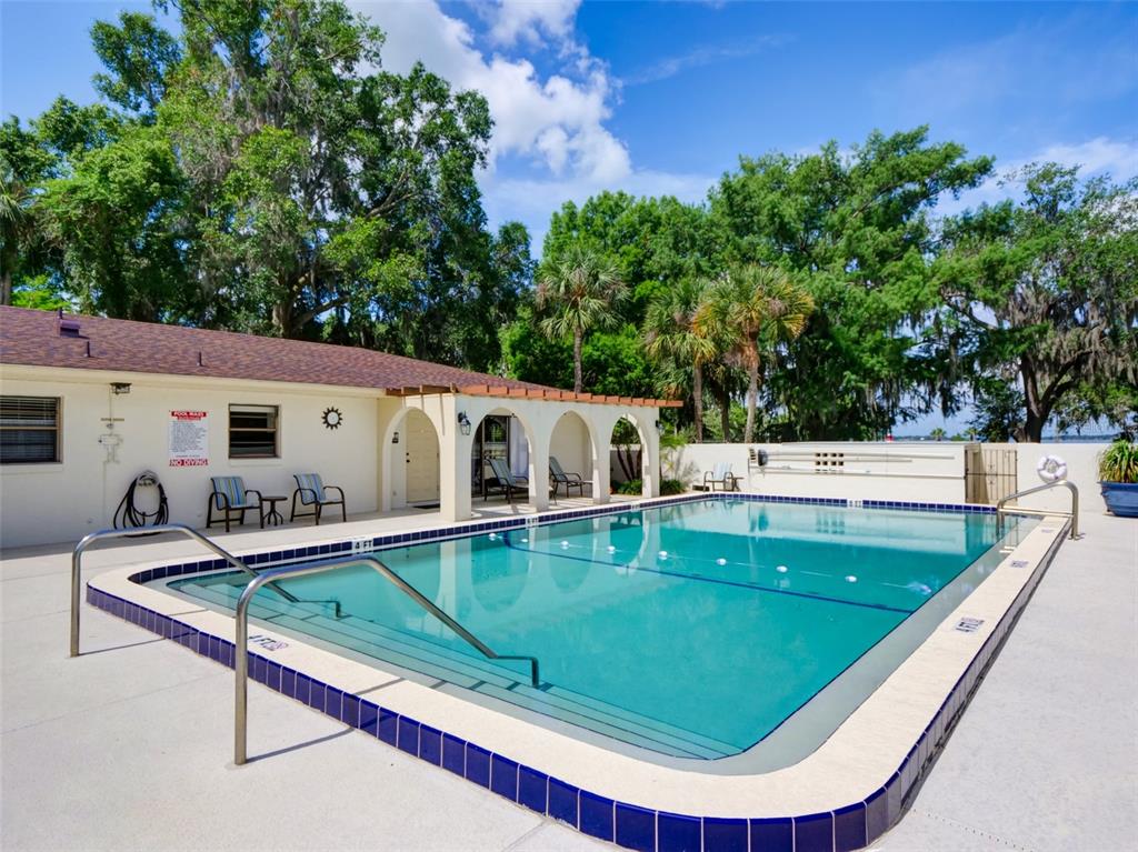 An exterior view shows a stucco wall with two arched iron gates and a brick walkway — 100 S TREMAIN STREET UNIT G2, MOUNT DORA, FL