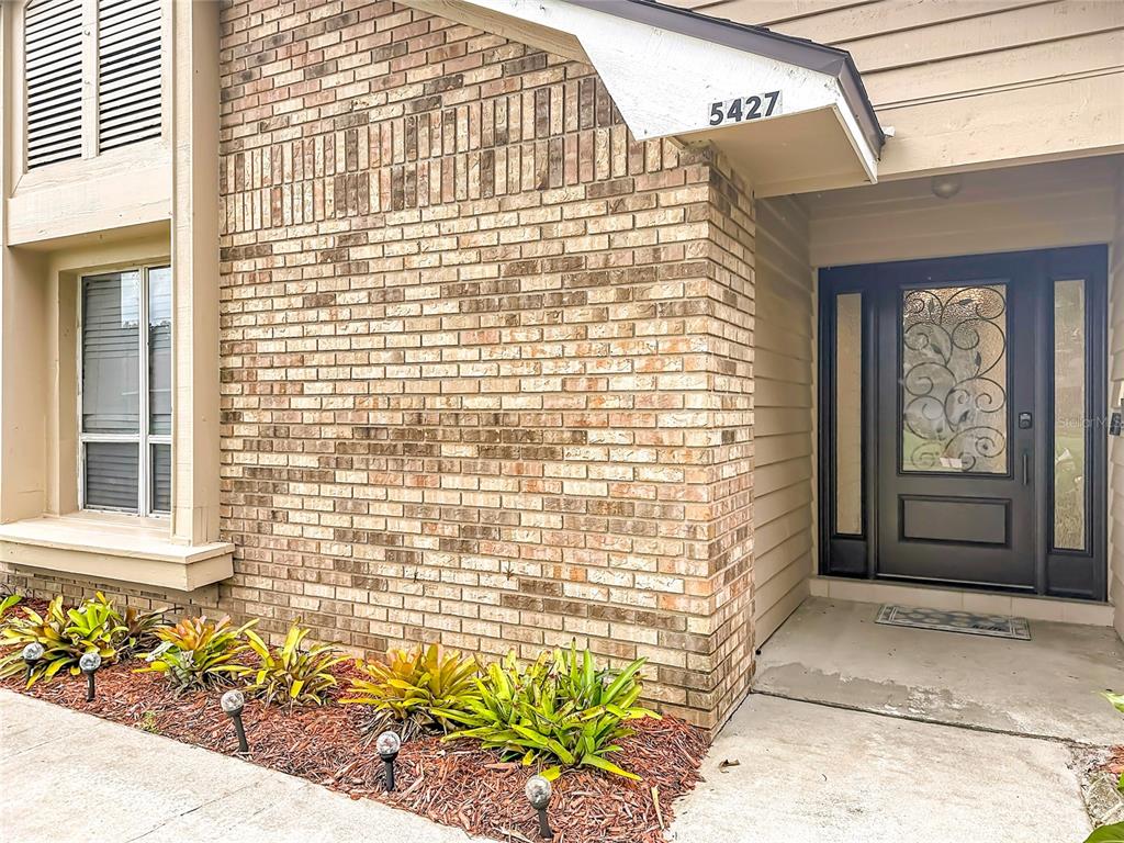 A built-in wooden shelving unit and cabinets stand next to a brick fireplace — 5427 SAGO PALM COURT, ORLANDO, FL