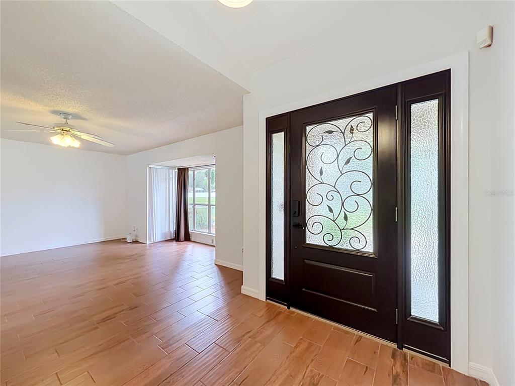 A kitchen features blue cabinets, stainless steel appliances, a central island, and wood-look flooring — 5427 SAGO PALM COURT, ORLANDO, FL