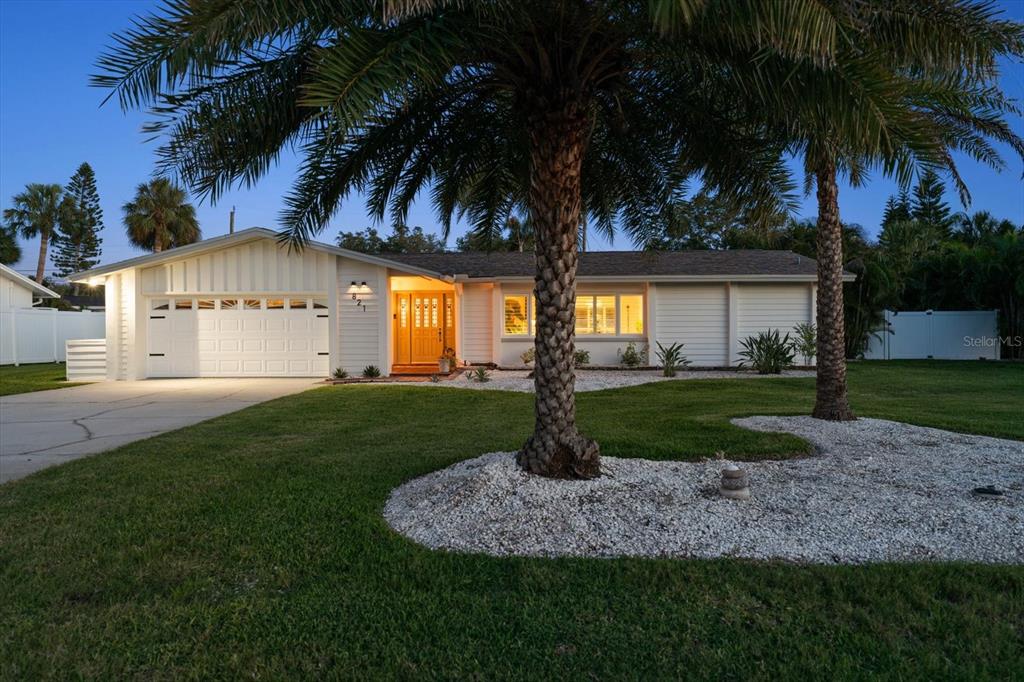 A single-story house with a white exterior, a two-car garage, and two palm trees — 821 JACARANDA DRIVE, LARGO, FL