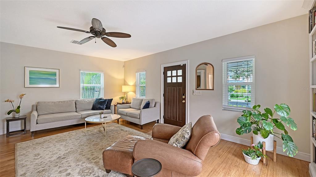 A living room features a fireplace, built-in shelving, a staircase, and neutral-toned furniture — 1685 6TH STREET, SARASOTA, FL