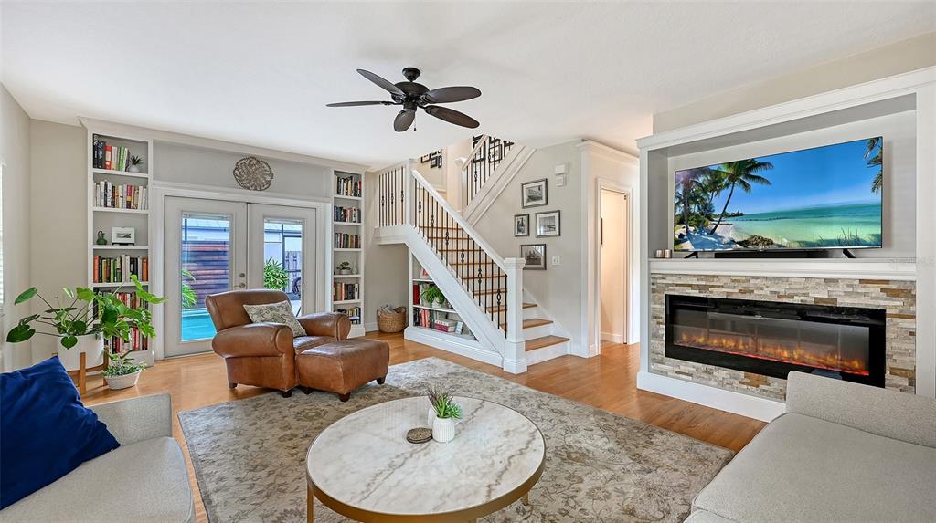 A living room features a fireplace with a built-in television, two sofas, and a coffee table — 1685 6TH STREET, SARASOTA, FL