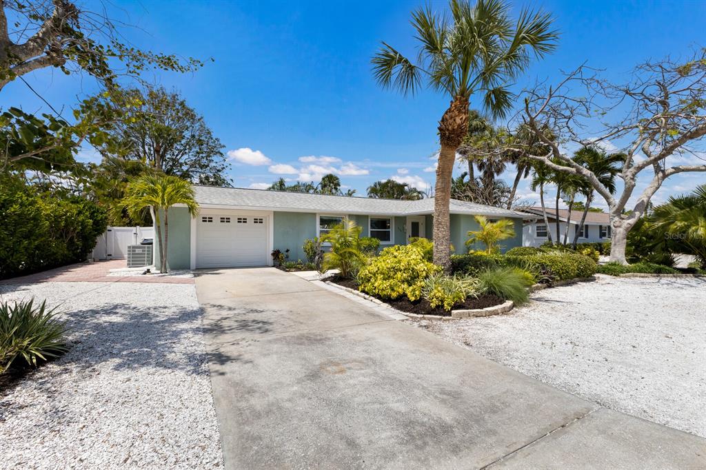 A light green single-story house with a white garage door and a concrete driveway — 506 69TH STREET, HOLMES BEACH, FL