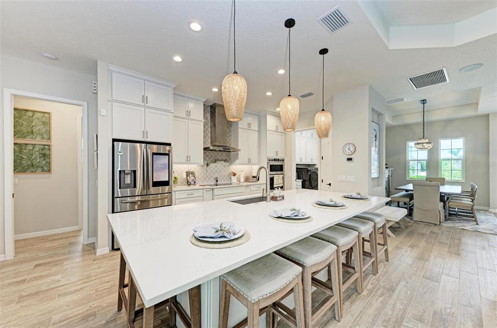A modern two-story house features a gray garage, a palm tree, and a sunset sky — 8211 37TH AVENUE CIRCLE W, BRADENTON, FL
