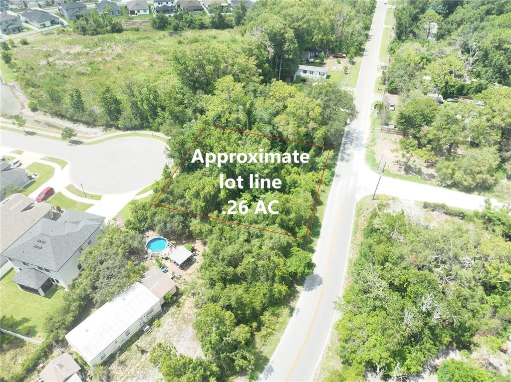 An aerial view shows a wooded lot outlined in red next to a paved road — Lot 50, 51, 52 LAKE DR, NEW PORT RICHEY, FL