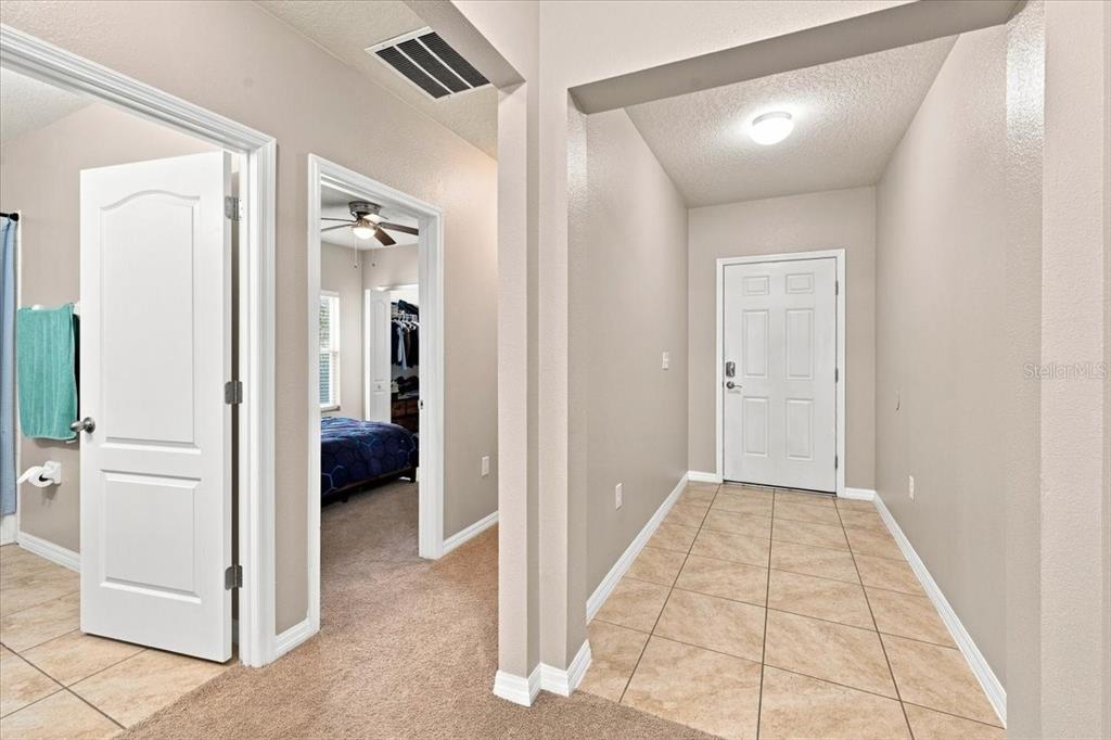 An interior view shows a tiled entryway, a carpeted hallway, and a bedroom doorway — 609 LUCERNE BOULEVARD, WINTER HAVEN, FL