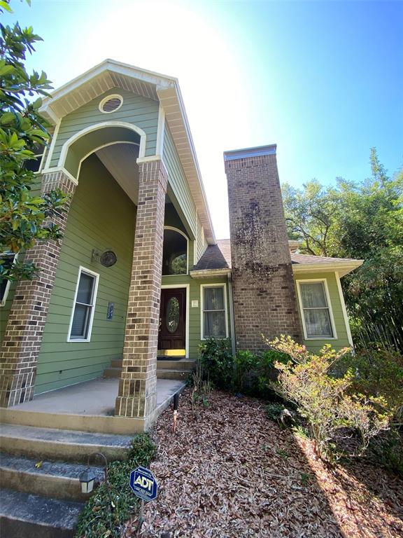 A two-story house with green siding, brick columns, and a prominent brick chimney — 1016 LAKESIDE DR. DRIVE, APOPKA, FL