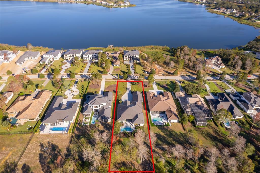 An aerial view shows a residential house with a pool and a large backyard — 15144 PENDIO DRIVE, BELLA COLLINA, FL