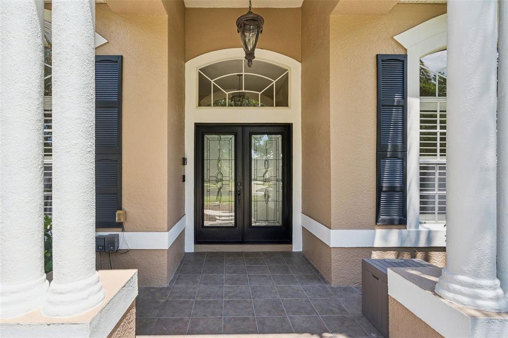 A tan single-story house with a palm tree, manicured hedges, and a concrete driveway — 2230 RIDGEWIND WAY, WINDERMERE, FL