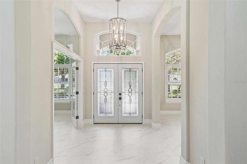 A single-story tan house with a palm tree, arched windows, and manicured landscaping — 2230 RIDGEWIND WAY, WINDERMERE, FL