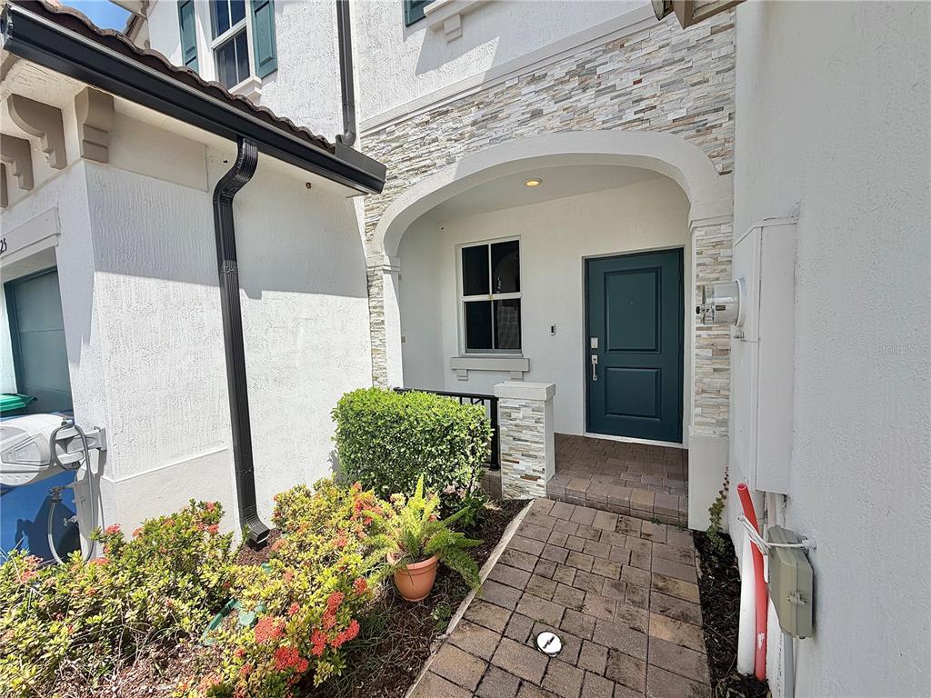 The exterior of a home features a stone-accented entryway with a dark green front door — 12621 NW 23RD PLACE, MIAMI, FL